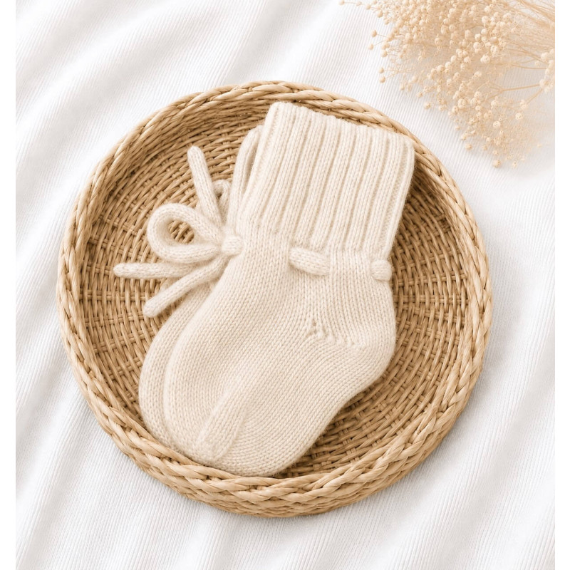 Gebreide offf-white babyslofjes gemaakt van merino wol.