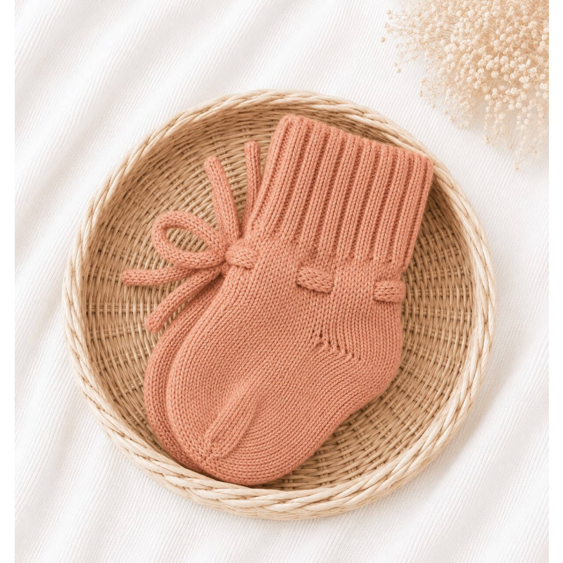 Gebreide roze babyslofjes gemaakt van merino wol.