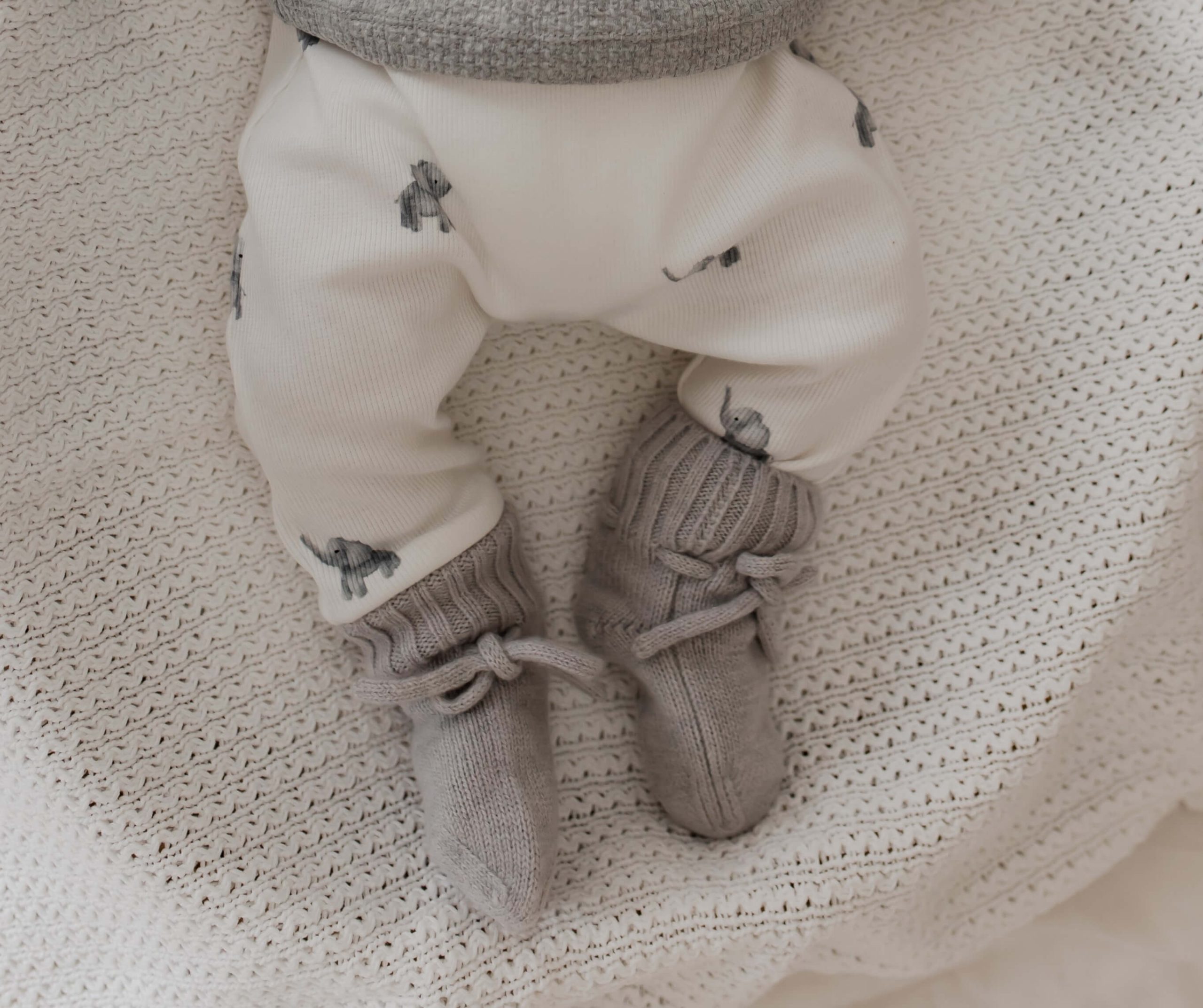 Newborn broekje met kleine olifantjes en grijze merino wollen slofjes.