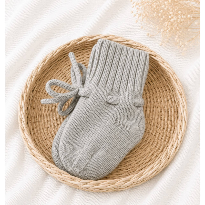 Gebreide grijze babyslofjes gemaakt van merino wol.