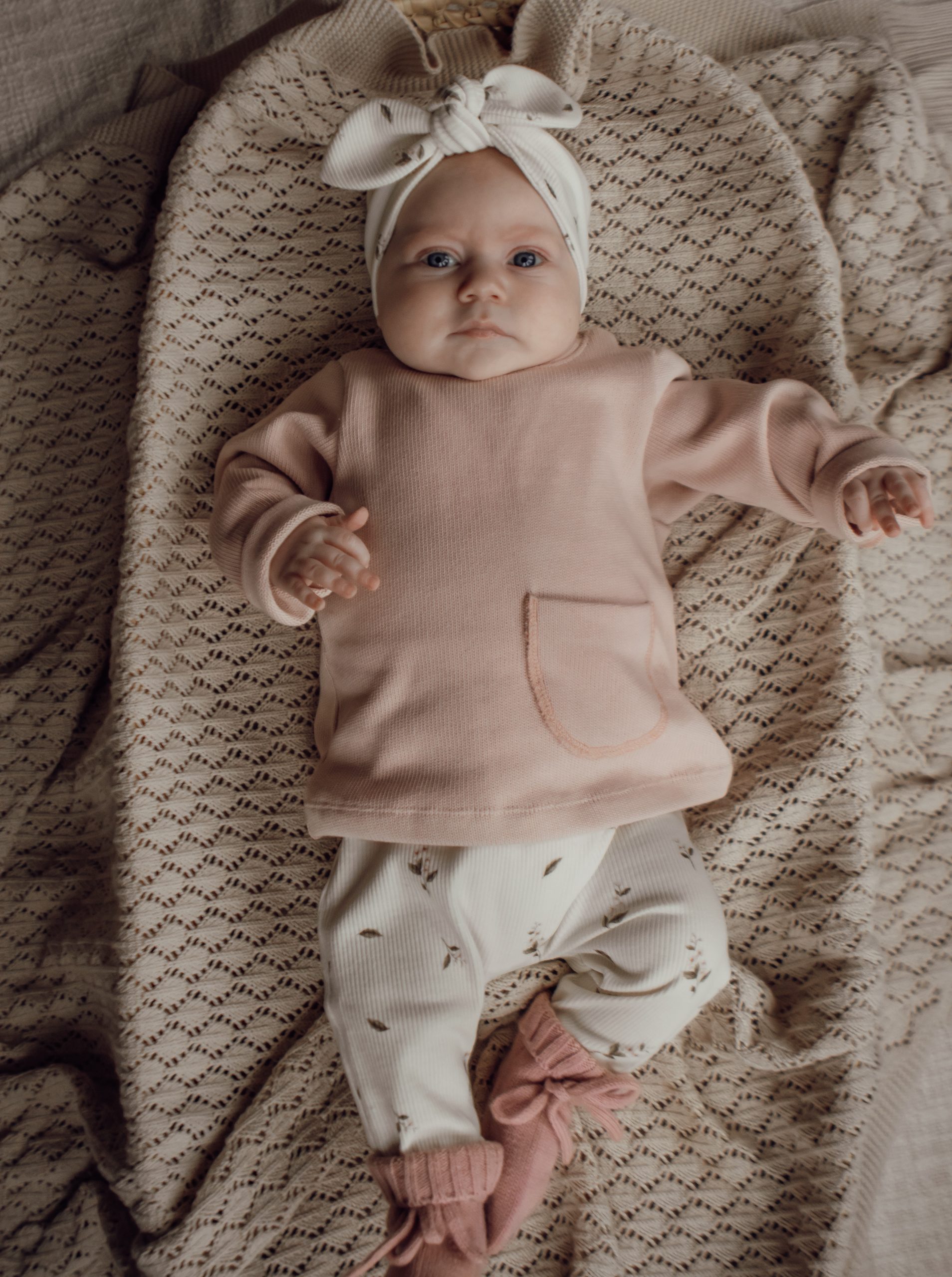 Newborn broekje met kleine roze roosjes in een ribstof.