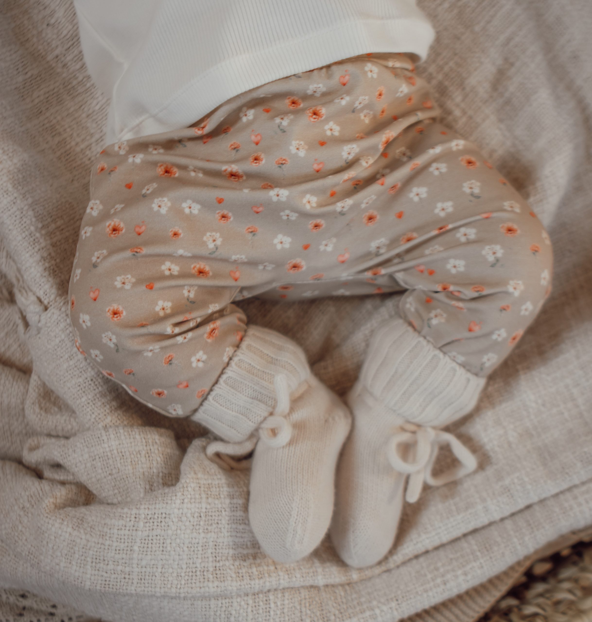 Newborn broekje in een zandkleur met kleine bloemetjes.