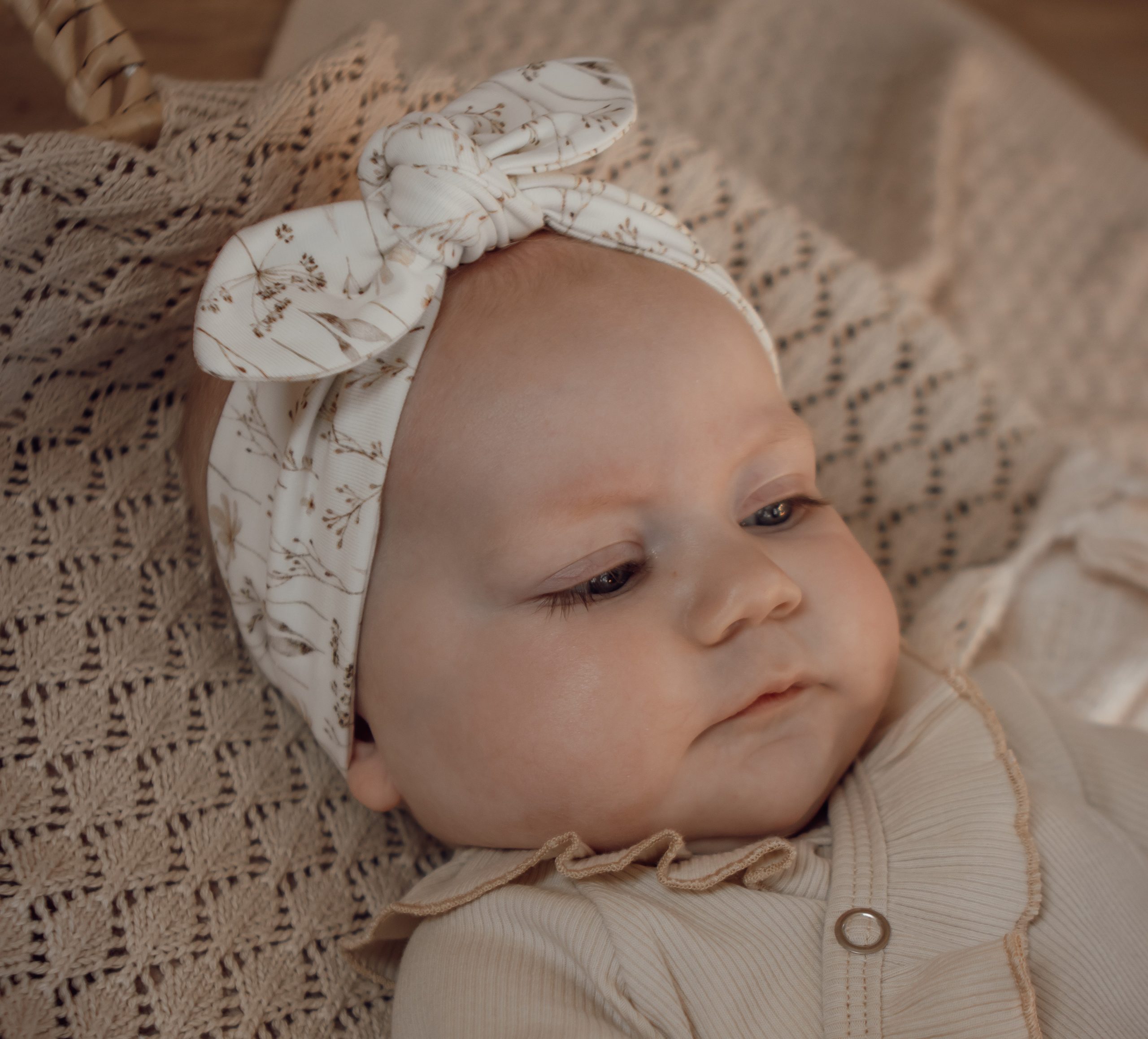 Newborn haarbandje met lichte zandkleurige bloemen.