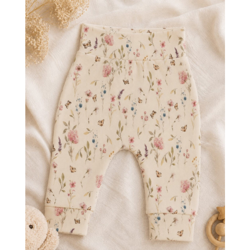 Een newborn ecru broekje met gekleurde bloemen.