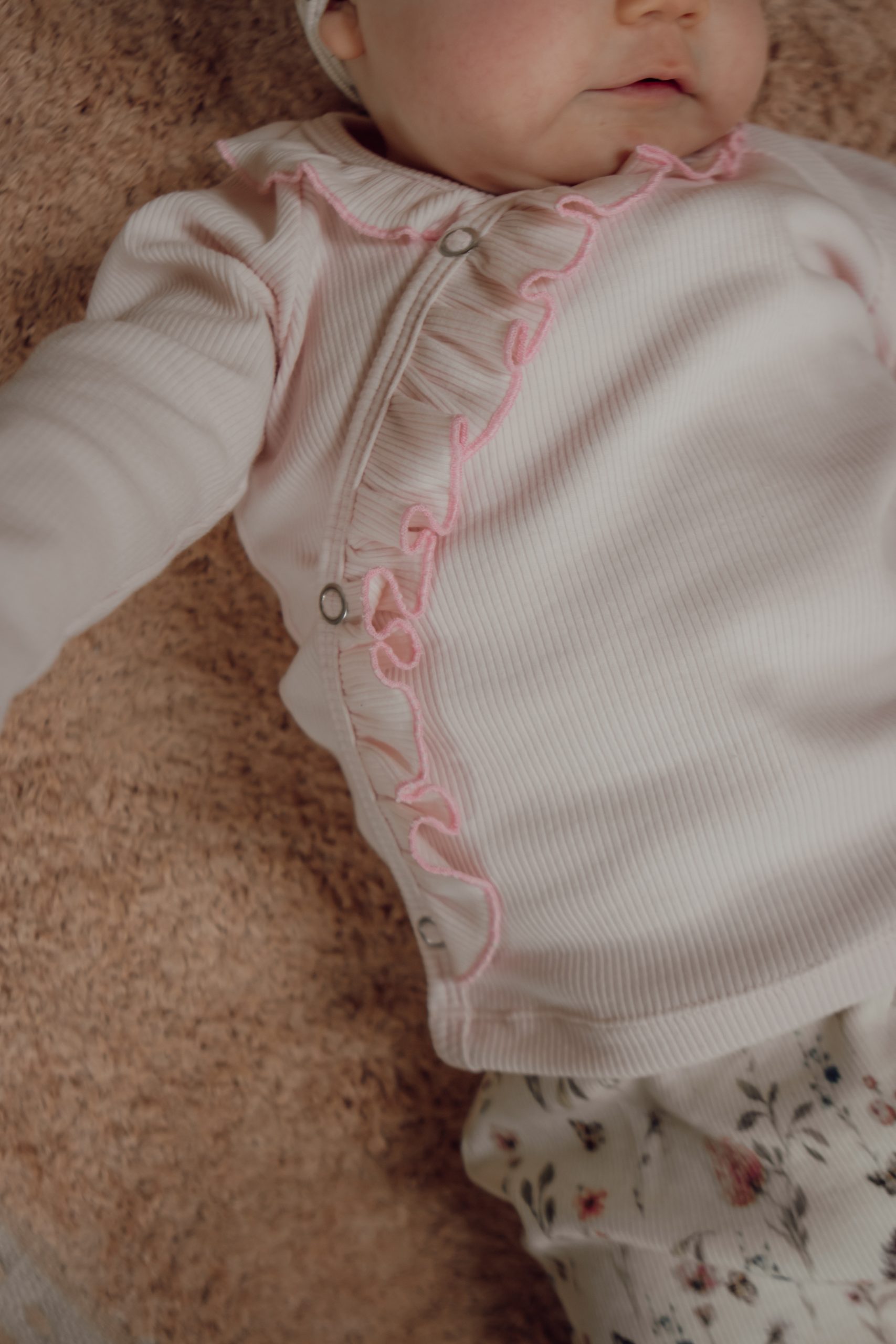 Newborn overslagshirtje in babyroze met ruffles