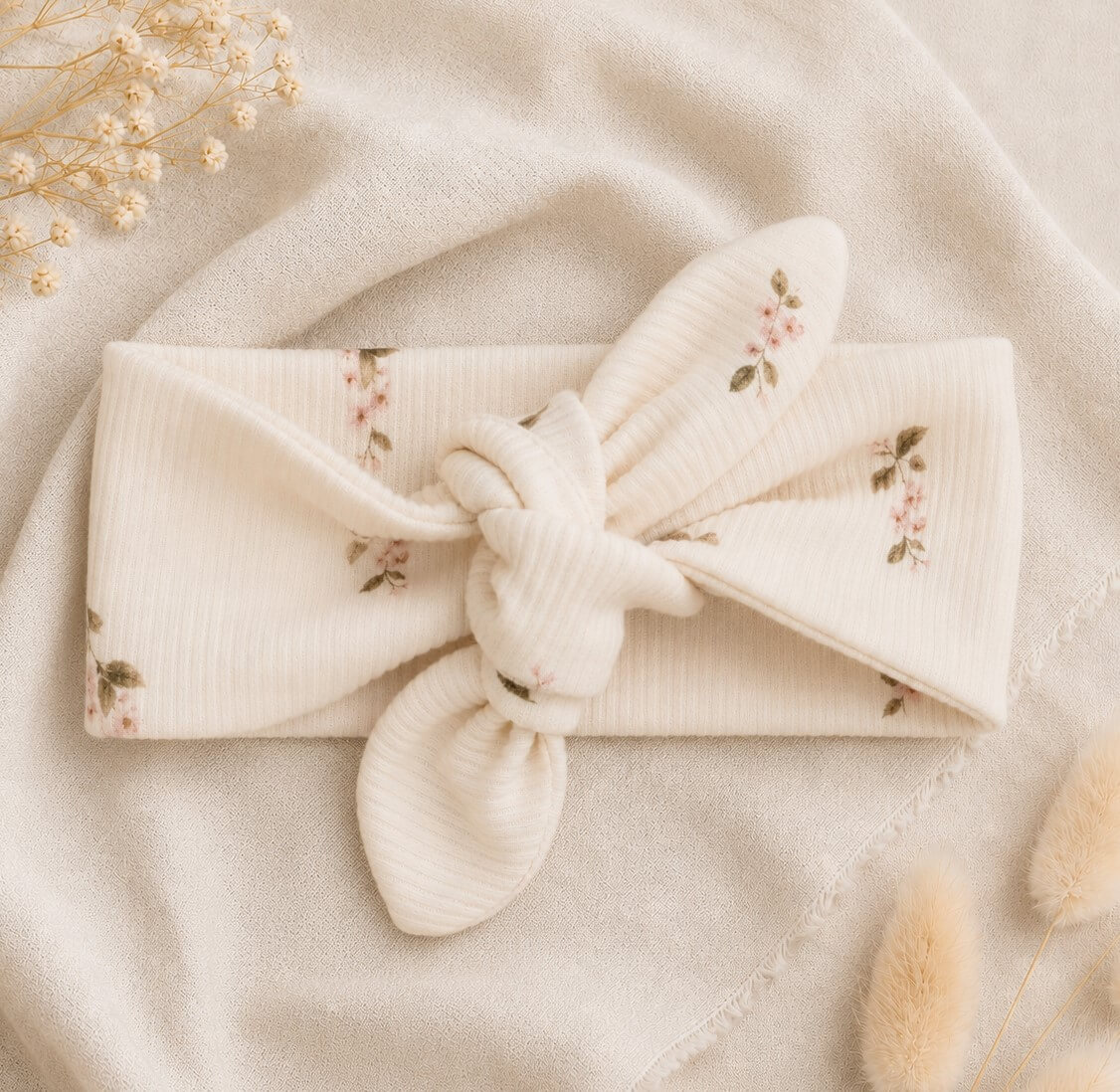 Newborn haarbandje met kleine roze roosjes in een ribstof.